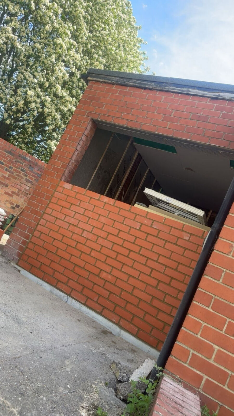 Red-brick outbuilding wall with a new opening formed