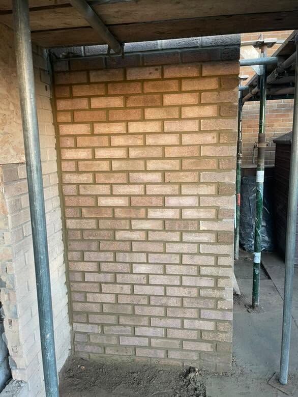 Buff brick infill panel built beneath scaffolding