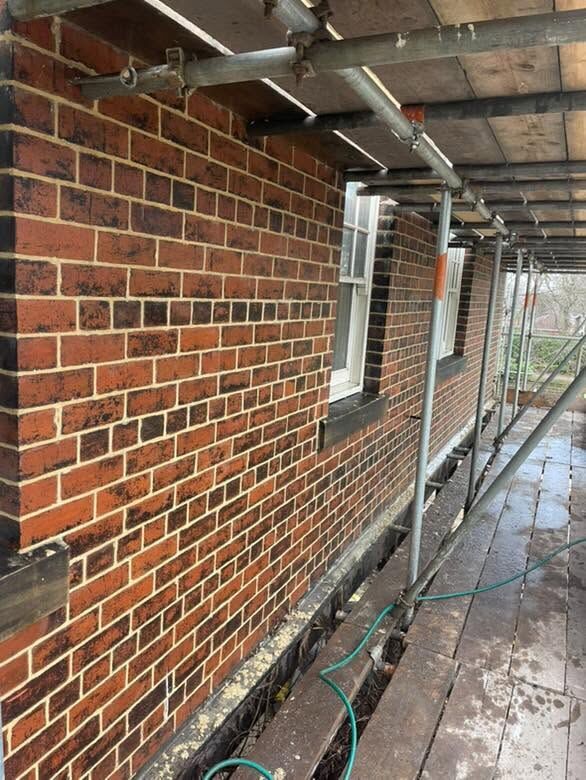 Red-brick wall being built under scaffolding