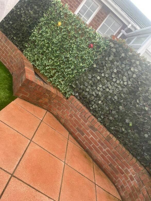 Low red-brick garden wall alongside a patio