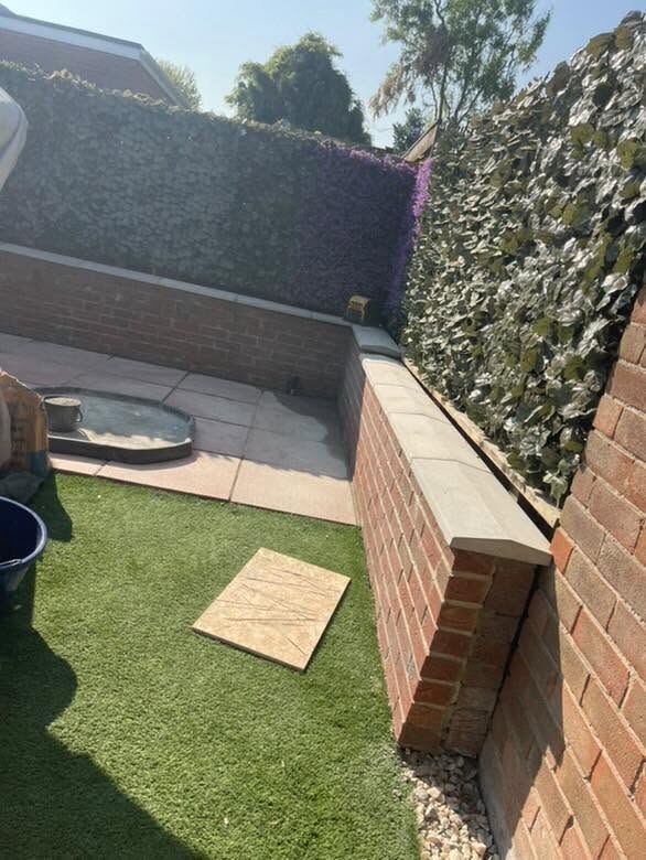 Brick garden walls with coping around an artificial lawn